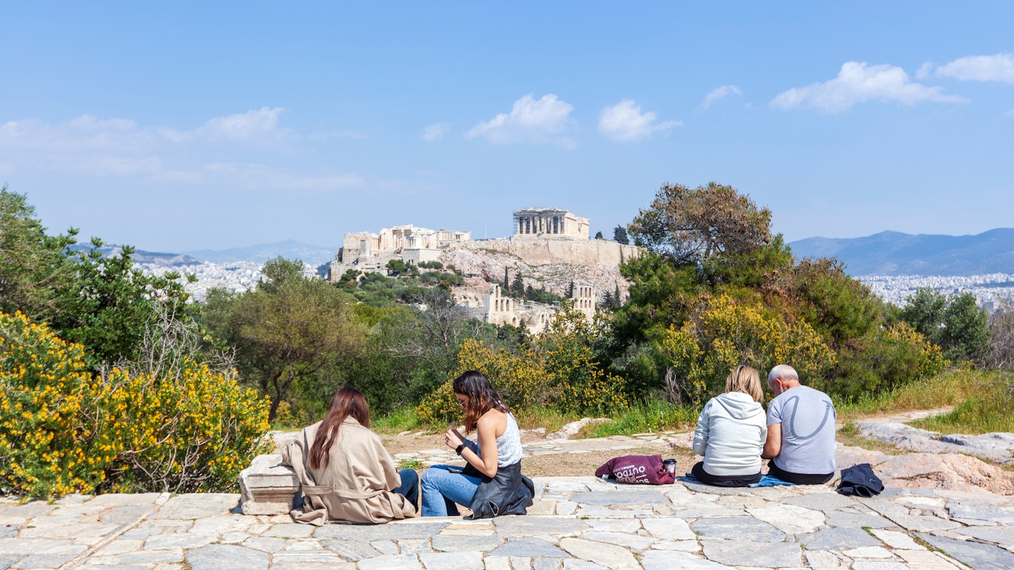 Locals relax in the sun on Filopappou Hill