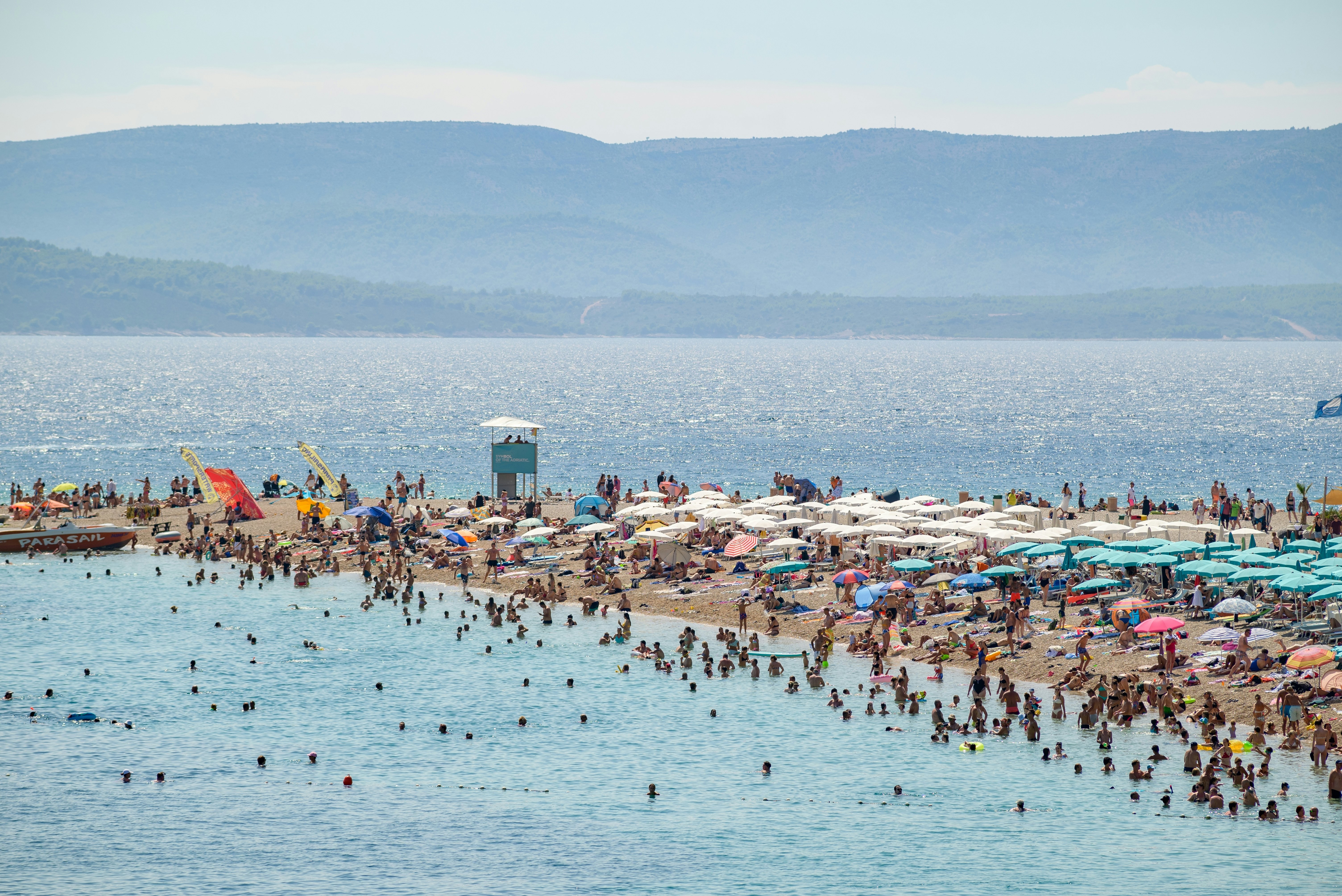 A busy beach day at Zlatni Rat on the southern coast of the island of Brač in Adriatic Sea.