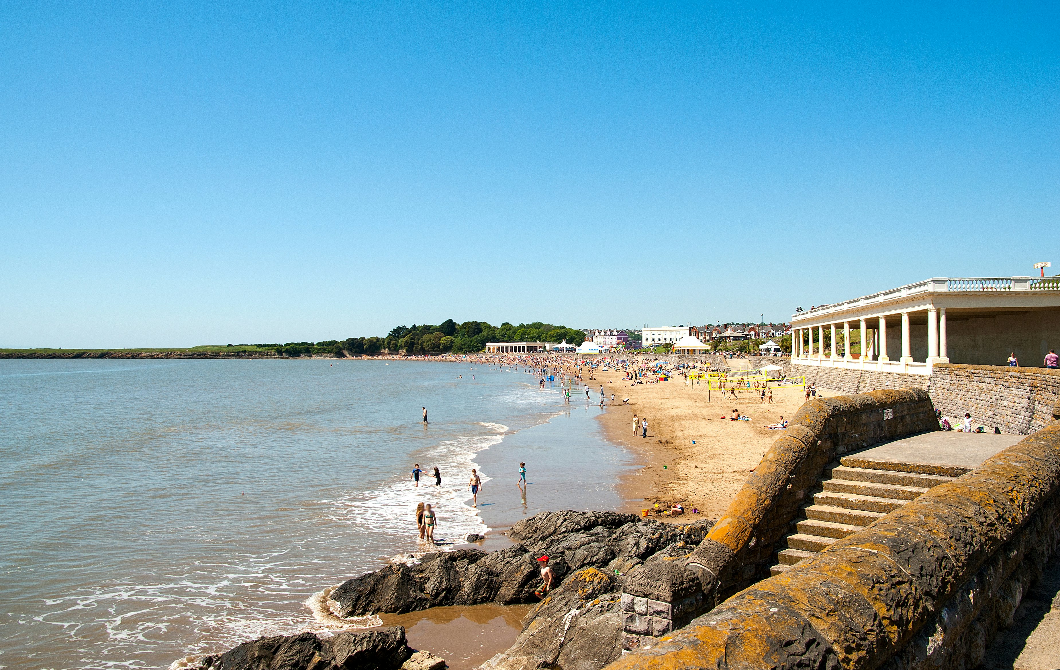 People playing and relaxing on a sandy beach on a sunny day